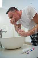 Man washing his mouth with water