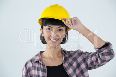 Female architect in hard hat standing against white background