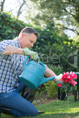 Man watering flowers with a watering can