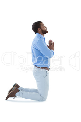 Male executive praying against white background