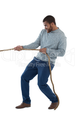 Male executive pulling the rope against white background
