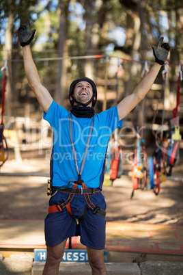 Excited man standing with arms up in park