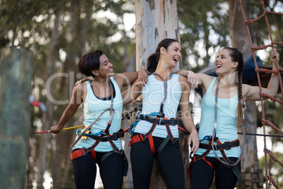 Female friends standing together with arm around in park