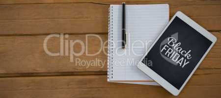 Composite image of blank notepad and digital tablet on wooden plank