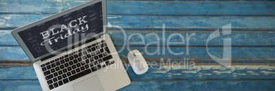 Composite image of laptop and mouse on wooden table