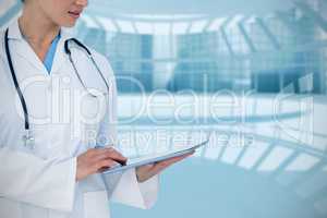 Composite image of happy doctor using her tablet pc