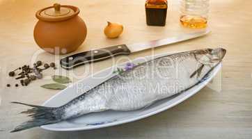 Herring on the table with ceramic dishes and spices.