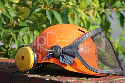 Helm mit Visier bei Gartenarbeit
