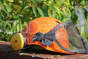 Helm mit Visier bei Gartenarbeit