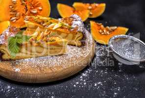 pumpkin pie on a round wooden board