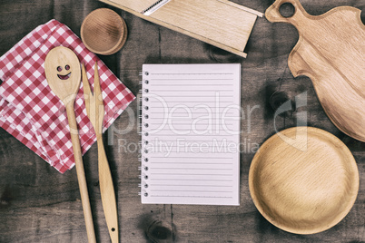 open notepad with wooden kitchen objects