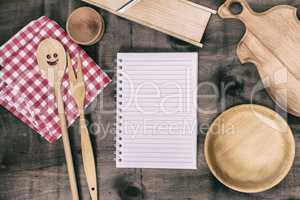 open notepad with wooden kitchen objects
