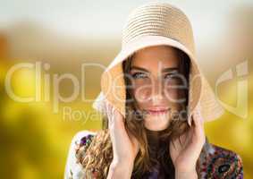 Woman's face in bright nature holding hat