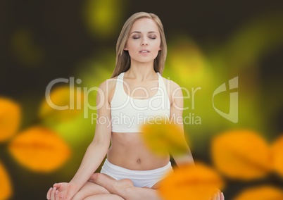 Woman meditating in forest with leaves