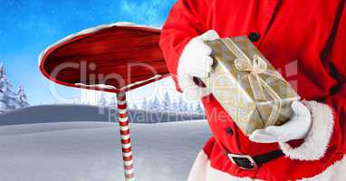 Santa holding gift and Wooden signpost in Christmas Winter landscape