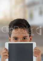 Boy holding tablet with bright blurred background