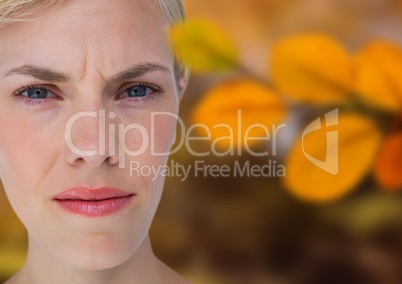 Concerned woman's face in forest with leaves