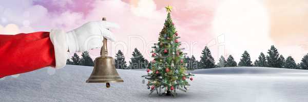 Santa holding bell in Christmas Winter landscape with Christmas tree