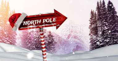 North Pole text on Wooden signpost in Christmas Winter landscape and Santa hat