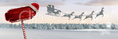 Wooden signpost in Christmas Winter landscape and Santa's sleigh and reindeer's