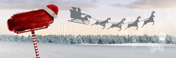 Wooden signpost in Christmas Winter landscape and Santa's sleigh and reindeer's