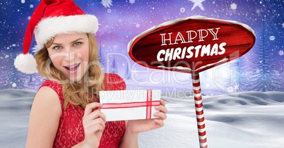 Happy Christmas text and female Santa holding gift with Wooden signpost in Christmas Winter landscap
