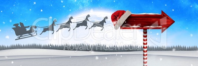 Wooden signpost in Christmas Winter landscape and Santa's sleigh and reindeer's