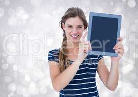 Woman holding tablet with sparkling lights background