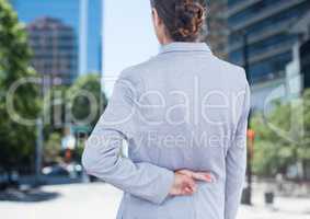 Businesswoman with fingers crossed in city