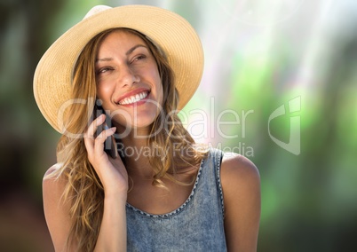 Woman on phone wearing hat in forest