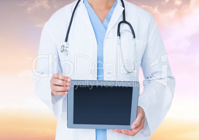 Doctor holding tablet with sky background