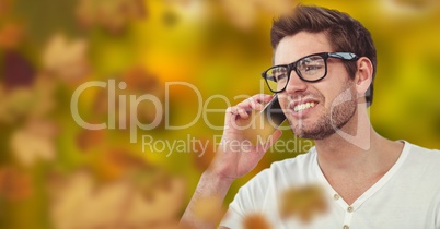 Man on phone in forest with leaves and glasses