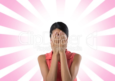 Woman holding face in hands with radial pink background