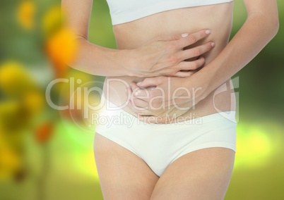 Woman's torso mid section in nature with leaves