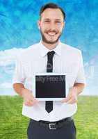 Man holding tablet with sky and green grass background