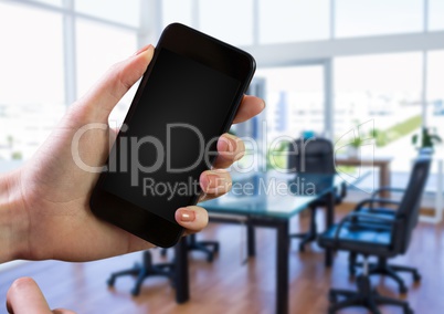 Hand using phone with office background