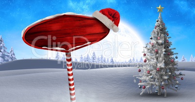 Wooden signpost in Christmas Winter landscape and Santa hat with Christmas tree