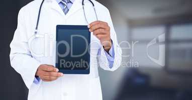 Doctor holding tablet with office background