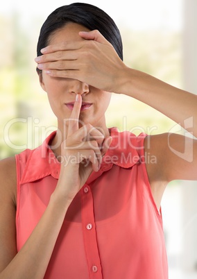 Woman hushing quiet with finger and hand over eyes