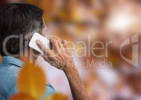 Man on phone in forest with leaves