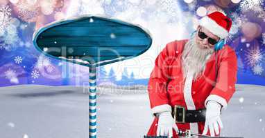 Santa DJ and Wooden signpost in Christmas Winter landscape