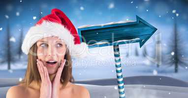 Amazed female Santa and Wooden signpost in Christmas Winter landscape