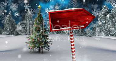 Wooden signpost in Christmas Winter landscape with Christmas tree