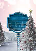 Wooden signpost in Christmas Winter landscape with Christmas tree
