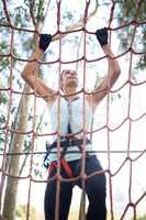 Determined woman climbing net