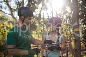 Coach assisting trainee in zip line