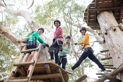 Friends getting ready to zip line in park