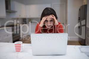 Tensed woman working on laptop