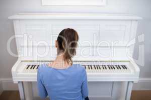Rear view of woman playing piano