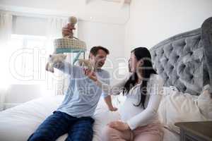 Happy man and pregnant woman holding toy